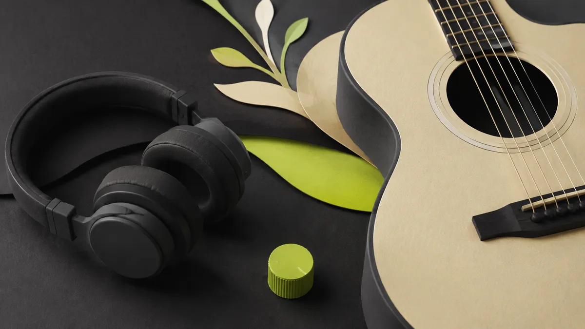 Headphones and an acoustic guitar beside a restrained lime volume control.