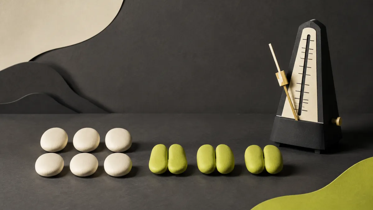 Six ivory stones in two groups of three beside six lime stones in three pairs and a metronome.